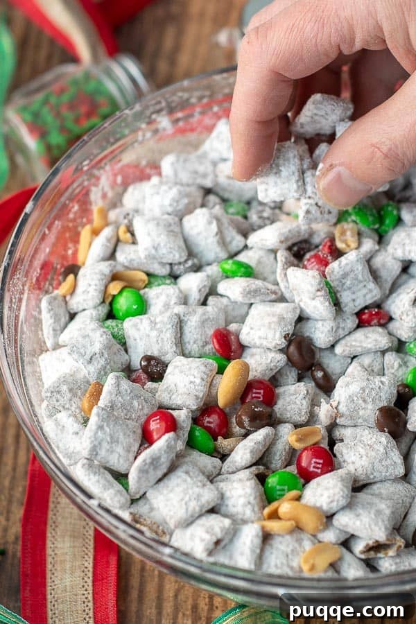 No Bake Nutella Puppy Chow Peanut Butter Free 3 A hand scooping up some festive Nutella Reindeer Chow, a holiday version of puppy chow.