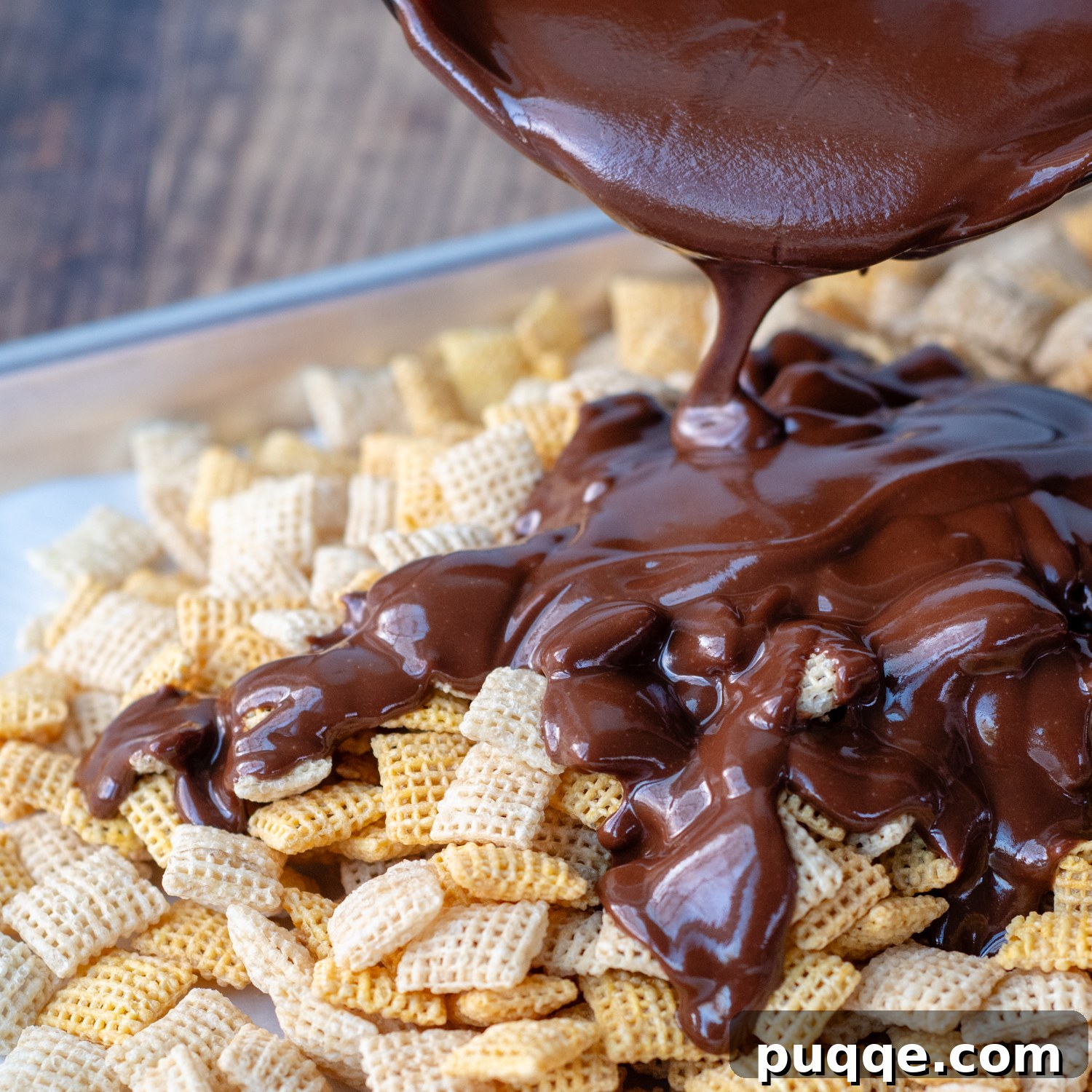 No Bake Nutella Puppy Chow Peanut Butter Free 4 Melted Nutella and butter mixture poured over Chex cereal on a baking sheet.