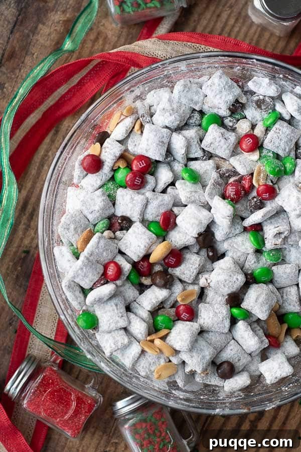 No Bake Nutella Puppy Chow Peanut Butter Free 6 An overhead shot of Nutella Puppy Chow in a Christmas version, adorned with festive ribbon and sprinkles nearby.