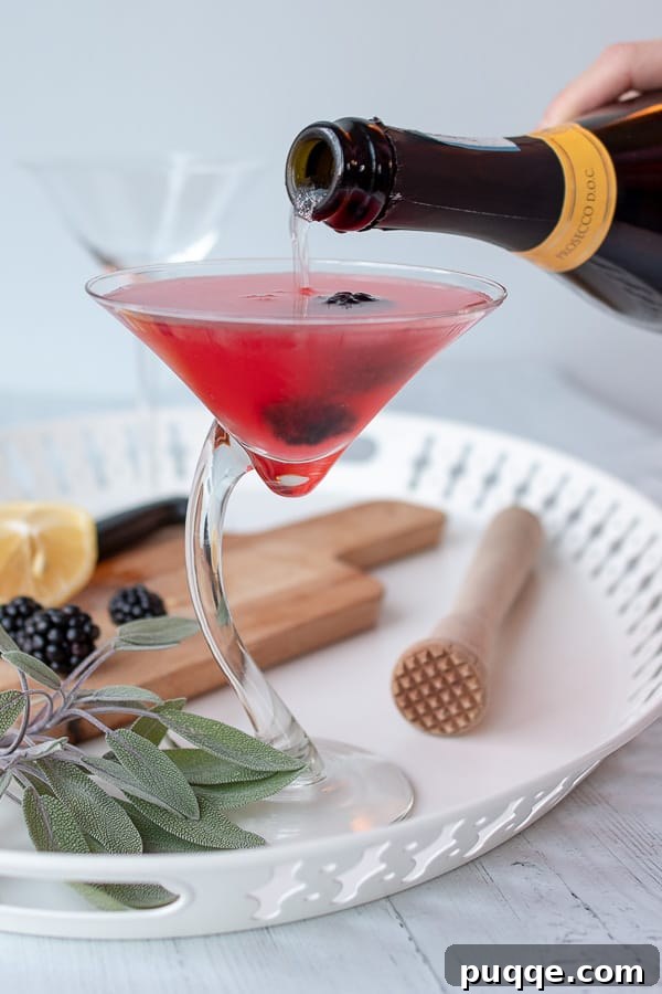 The Ultimate Blackberry Martini 6 A bottle of sparkling Prosecco being poured gracefully into a freshly prepared blackberry martini glass.