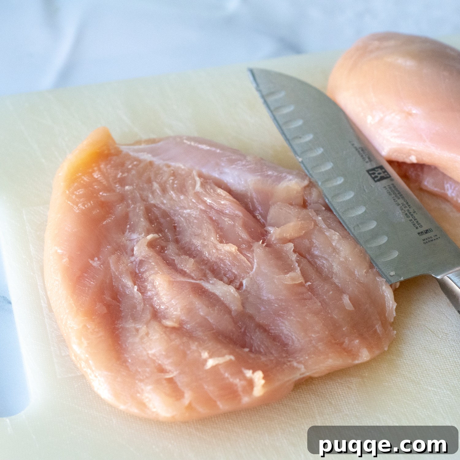 A butterflied chicken breast lying open like a book, ready for filling.