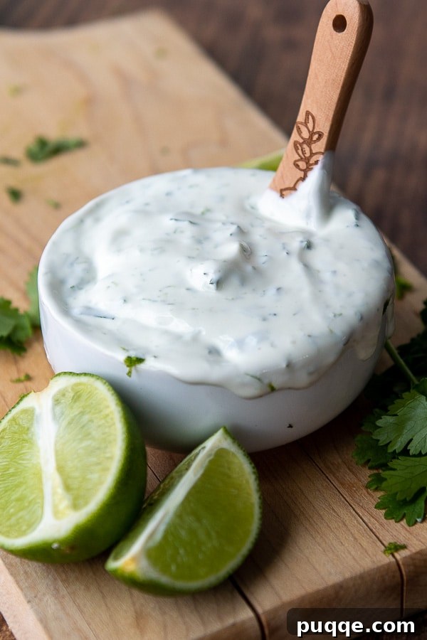 A bowl of vibrant green lime sour cream, perfect for topping tacos