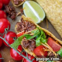 Close up of beef taco with tomatoes, cheese, and lettuce