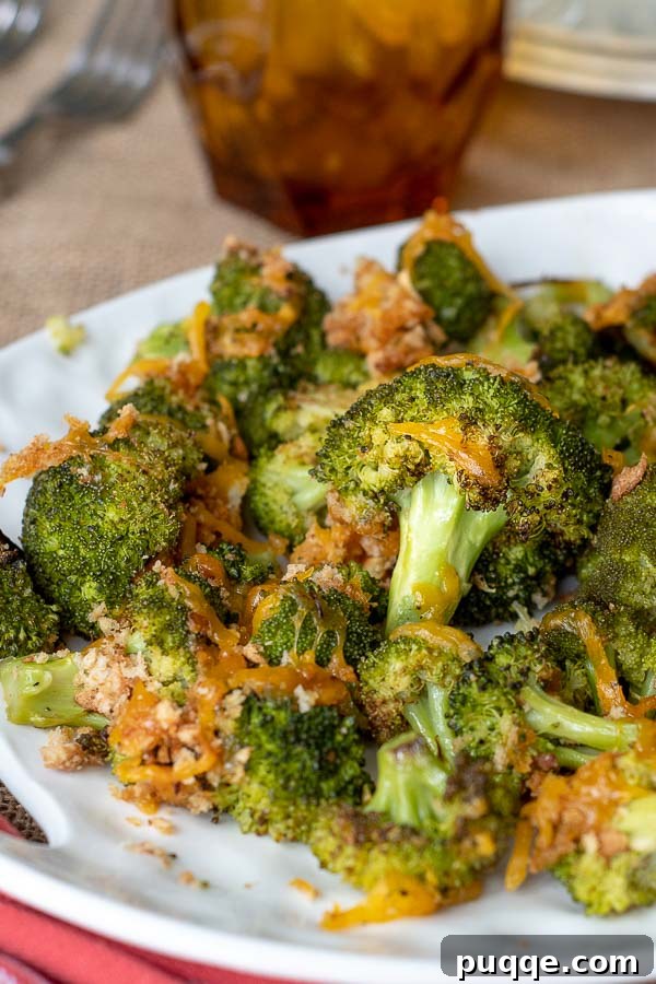 A pile of baked broccoli and cheese on a white serving dish, ready to be enjoyed.
