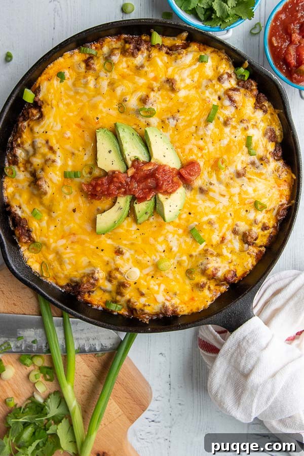 Authentic Gluten-Free Tamale Pie Made From Scratch 3 An overhead view of a freshly baked Tamale Pie in a cast iron skillet, golden brown and bubbling with cheese.