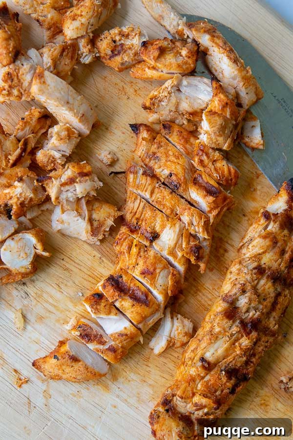 Sliced grilled buffalo chicken tenders on a wooden cutting board, ready for taco assembly