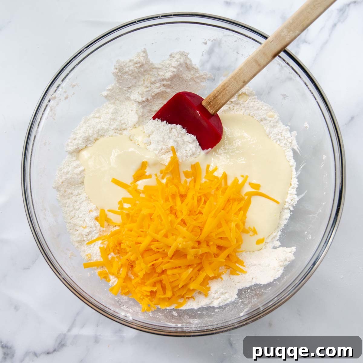 Melt-in-Your-Mouth Gluten-Free Cheddar Scones 5 Cheddar cheese and yogurt mixture being stirred into the dry ingredients, forming a soft dough.