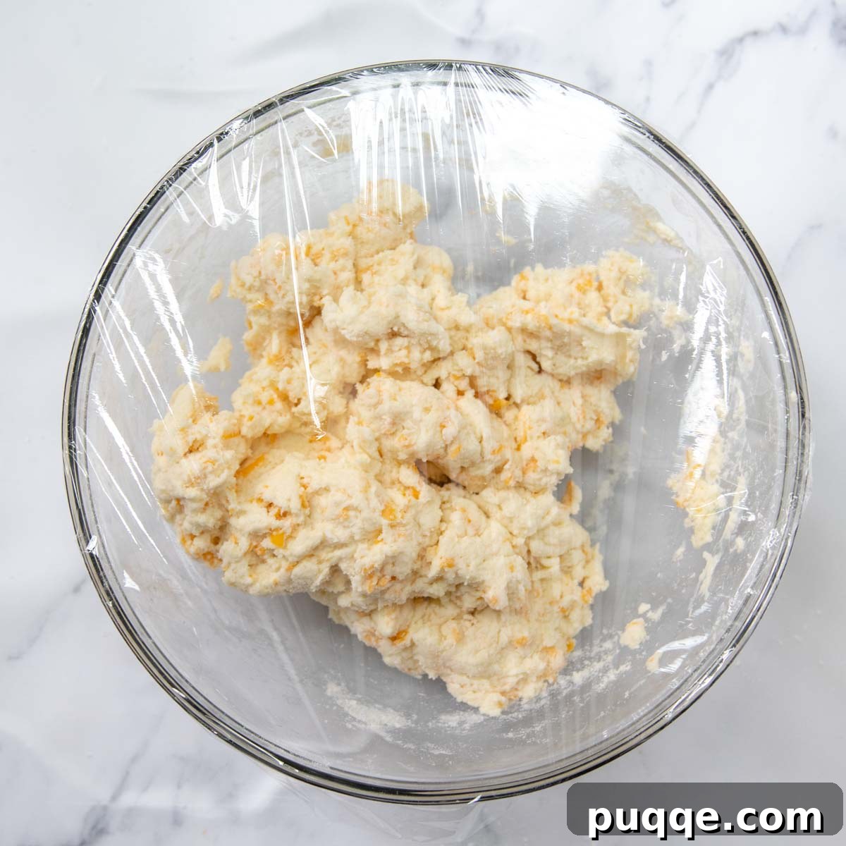 Melt-in-Your-Mouth Gluten-Free Cheddar Scones 6 Scone dough covered with plastic wrap, resting in a bowl before baking.