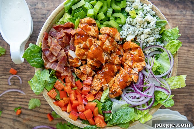 An overhead view of a large salad bowl filled with an assembled Buffalo Chicken Salad, ready to be served.