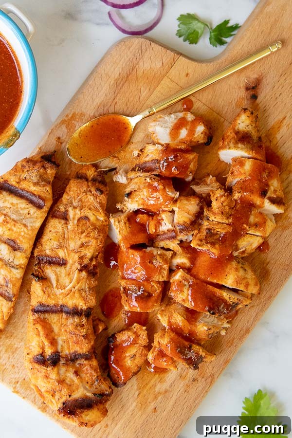 Chopped grilled buffalo chicken pieces arranged neatly on a wooden cutting board.