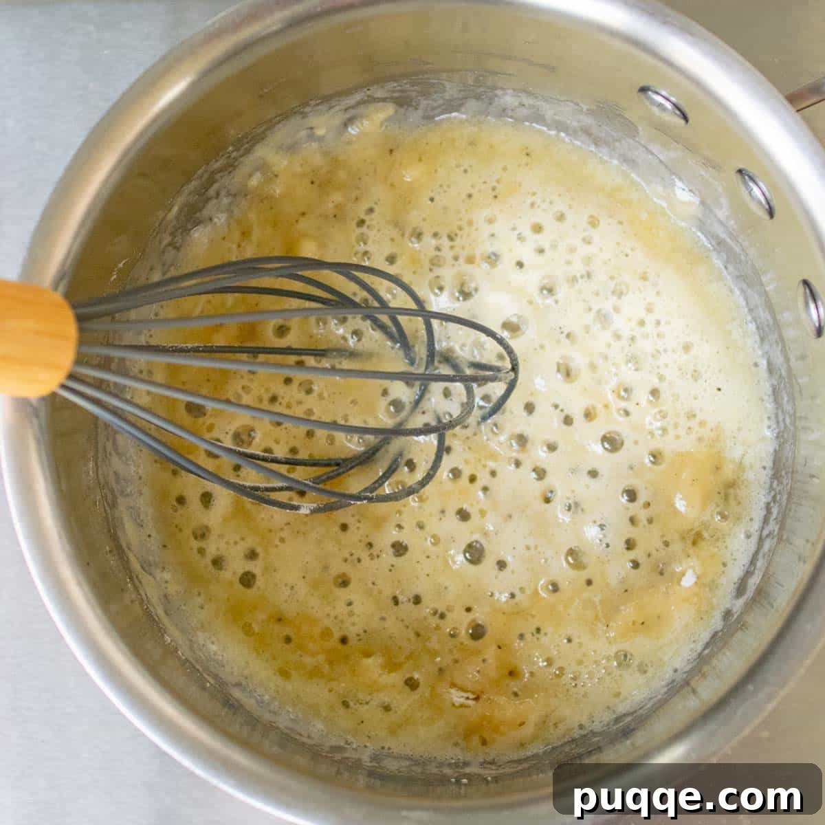 A large saucepan on the stovetop showing butter and flour gently bubbling, forming a roux as the base for the cheese sauce.
