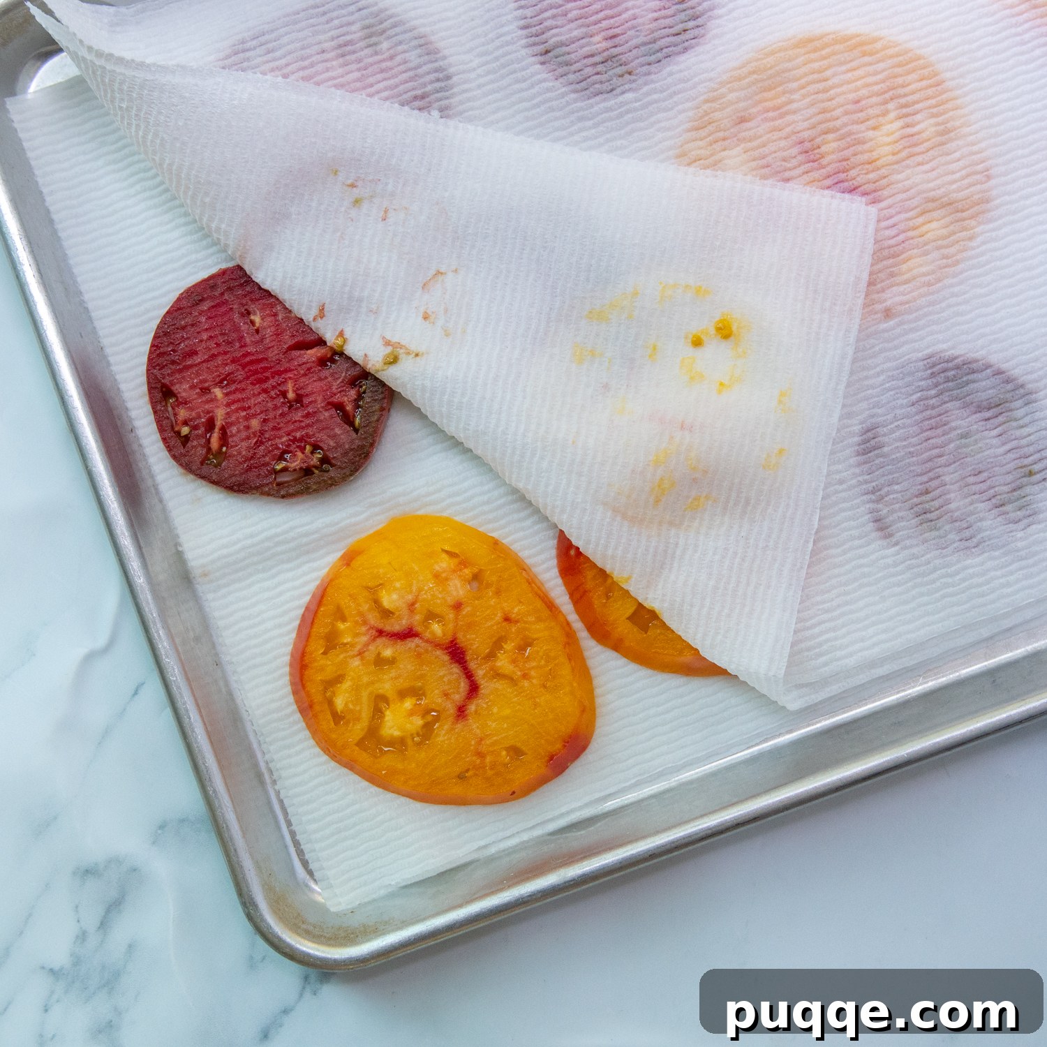 Easy Bisquick Tomato Pie 6 Sliced tomatoes draining on a baking sheet covered with paper towels, essential for preventing a soggy tomato pie.