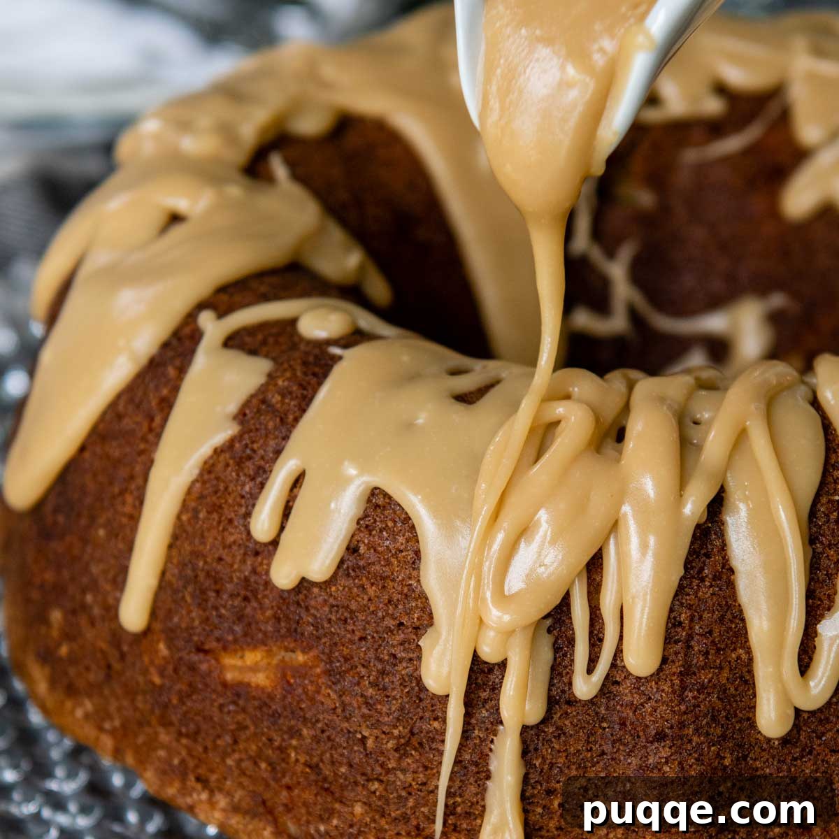 Brown Sugar Praline Glazed Apple Cake 11 Rich brown sugar praline glaze being drizzled artfully over a cooled bundt cake, creating luscious drips.
