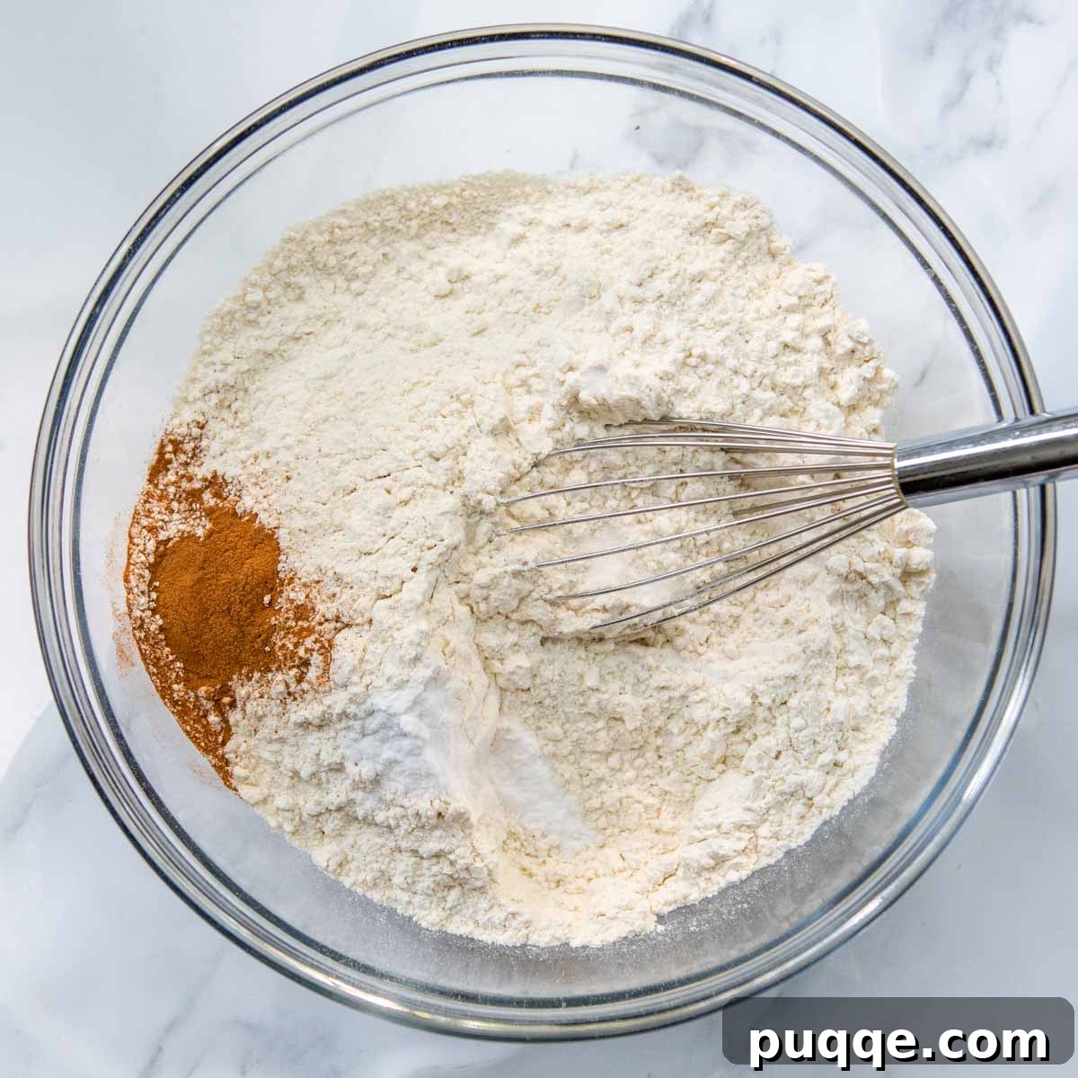Brown Sugar Praline Glazed Apple Cake 4 Dry ingredients for apple cake being whisked together in a mixing bowl.