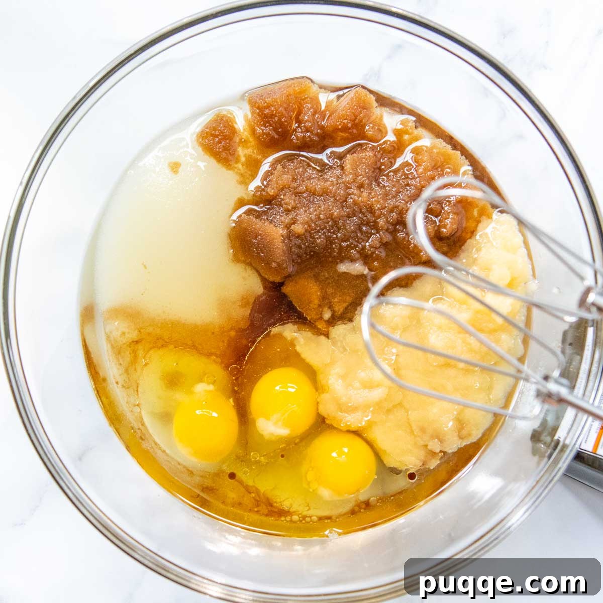 Brown Sugar Praline Glazed Apple Cake 5 Wet ingredients being beaten together vigorously in a large bowl for the apple cake batter.