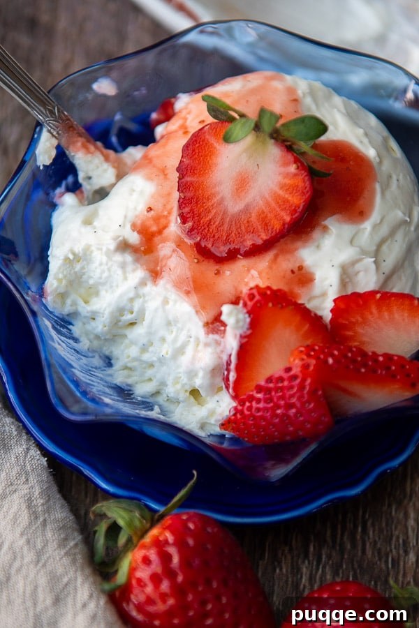Silky Coeur a la Creme with Vibrant Strawberries 4 A single serving of Coeur à la Crème in a dish, artfully drizzled with strawberry sauce and garnished with fresh berries.