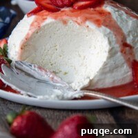 A Coeur à la Crème with a big scoop taken out on a serving platter with fresh strawberries.
