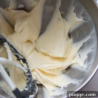 Showing cream cheese and powdered sugar mixture being beaten.