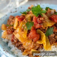 A close-up shot of a single serving of unstuffed cabbage rolls in a small white bowl, showcasing the rich sauce and tender ingredients.