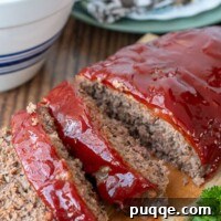 instant pot meatloaf sliced on a wooden board with a bowl of mashed potatoes in the background
