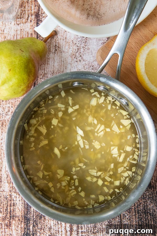 Crafting Perfect Fresh Ginger Simple Syrup 3 A saucepan filled with ginger simple syrup, showing fresh chopped ginger infusing in the liquid.