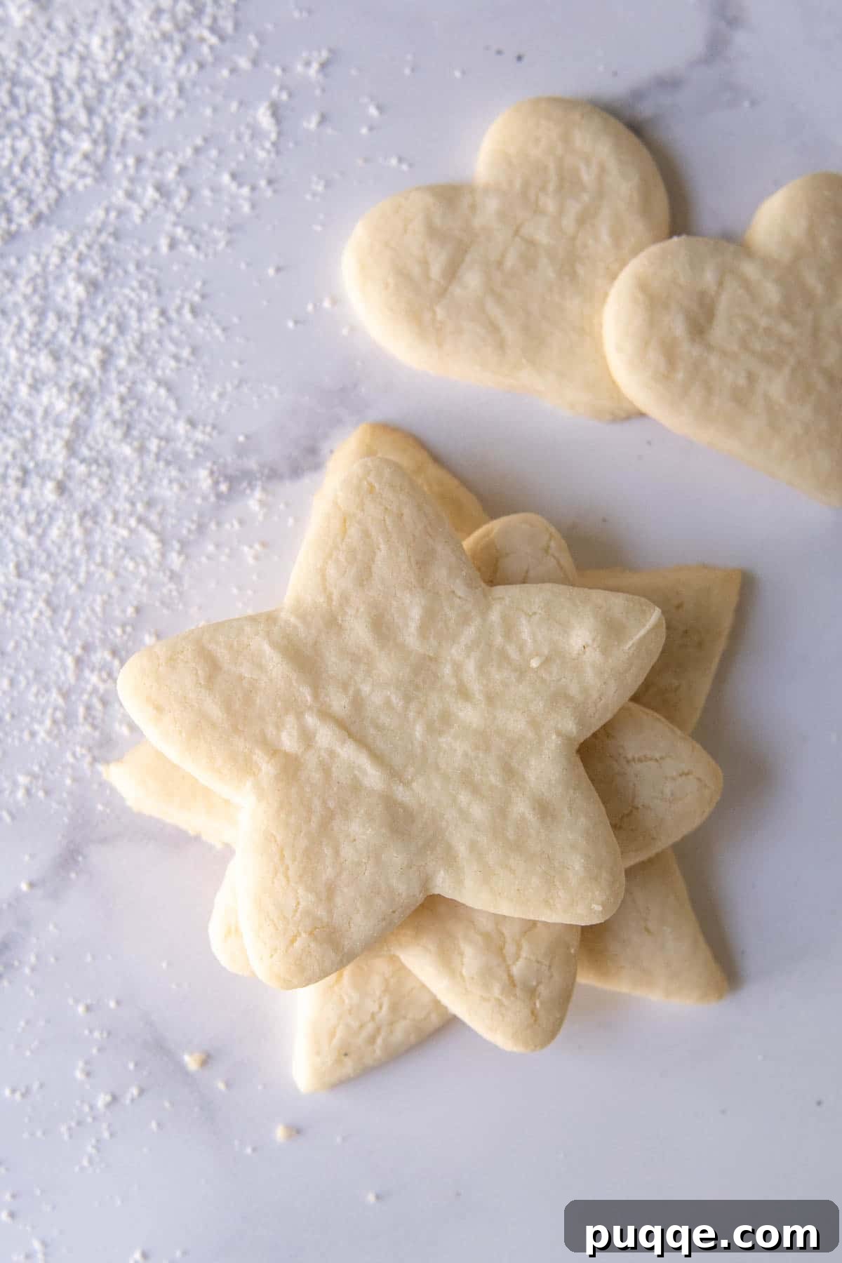 Flawless Gluten-Free Cut-Out Sugar Cookies 6 Unfrosted gluten-free sugar cookies arranged on a white marble surface, ready for decorating.