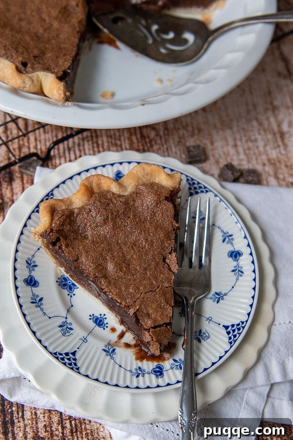 Decadent Southern Chocolate Chess Pie 6 overhead shot of a slice of pie on a blue and white plate with fork resing on it