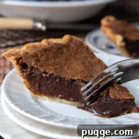 Decadent Southern Chocolate Chess Pie 8 a fork cutting into a piece of chocolate chess pie