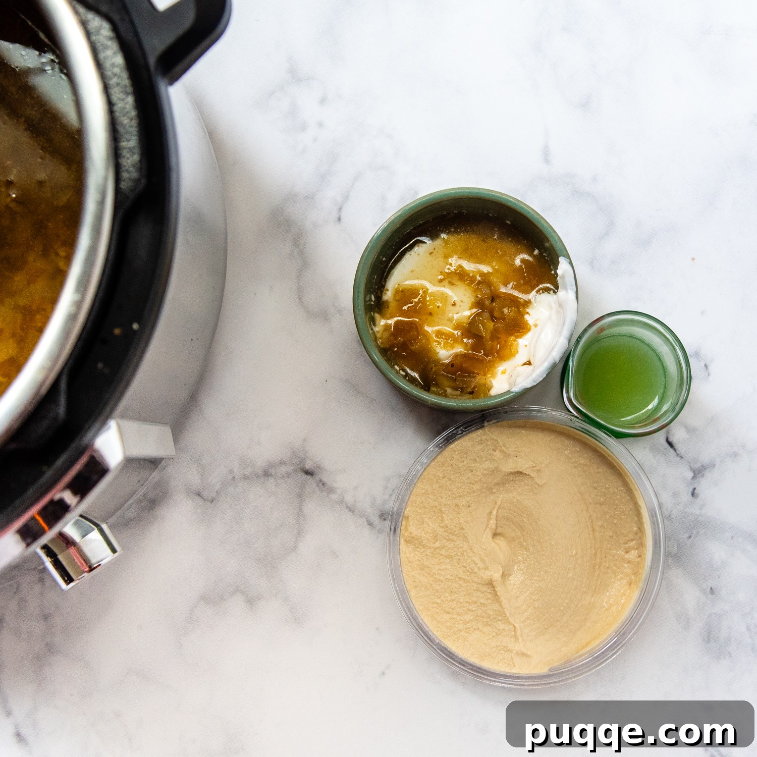 Gluten-Free White Chicken Chili The Secret to Its Deliciousness 5 Ingredients for finishing touches, including hummus, sour cream, and fresh lime juice, neatly arranged.