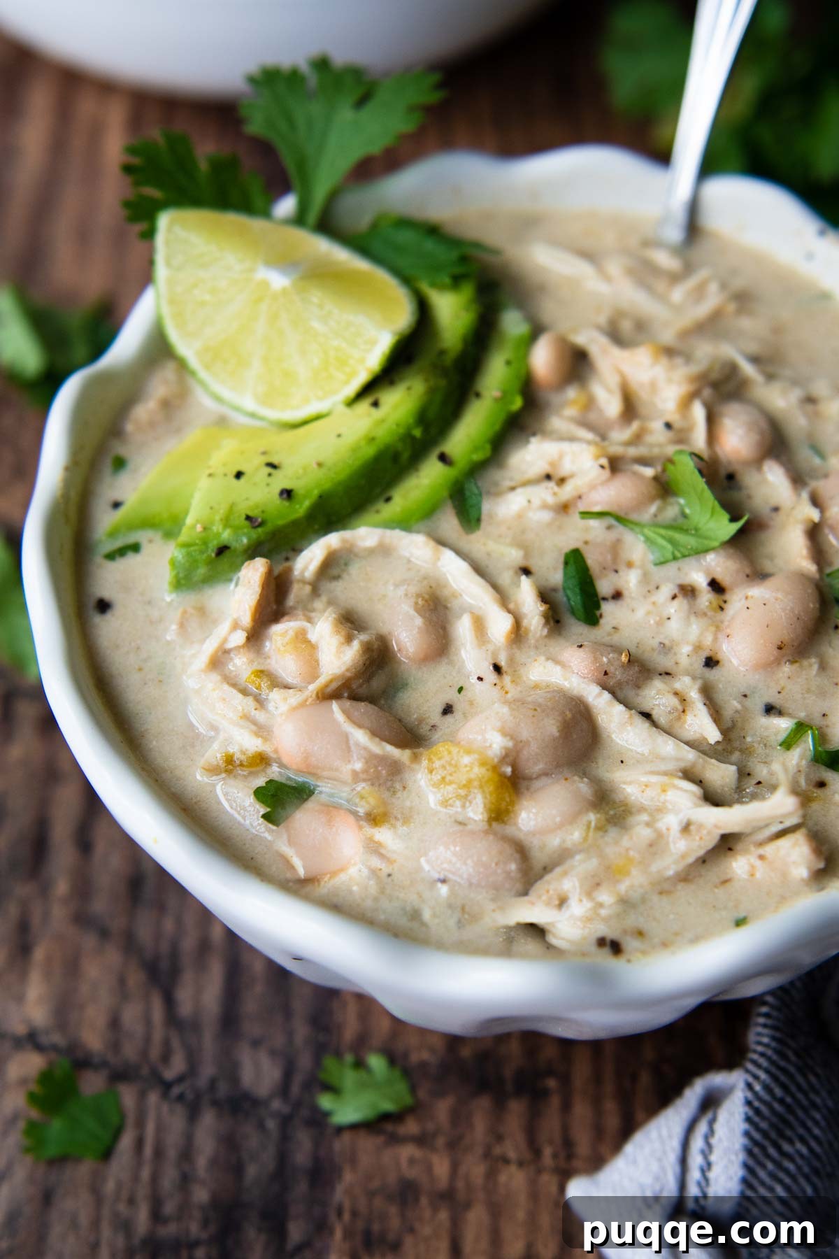 Gluten-Free White Chicken Chili The Secret to Its Deliciousness 7 A comforting bowl of creamy white chicken chili with a spoon resting in it, ready to be enjoyed.