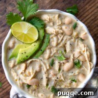 Gluten-Free White Chicken Chili The Secret to Its Deliciousness 8 Overhead shot of Instant Pot white chicken chili with sliced avocados, cilantro, and lime wedge on top