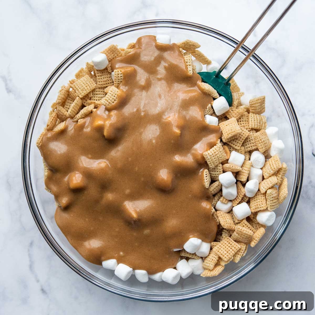 The warm, smooth peanut butter mixture being poured over the dry ingredients in a large bowl, ready to be gently mixed and coated for Scotcheroos.