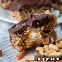 A bite taken out of a Gooey Scotcheroo with Marshmallows, revealing its soft, chewy interior and rich chocolate butterscotch topping.