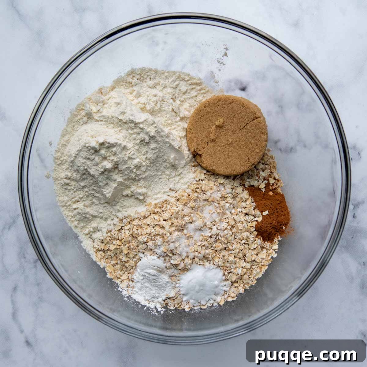 Wholesome Applesauce Oat Muffins 3 Dry ingredients like flour, oats, and cinnamon mixed in a bowl.