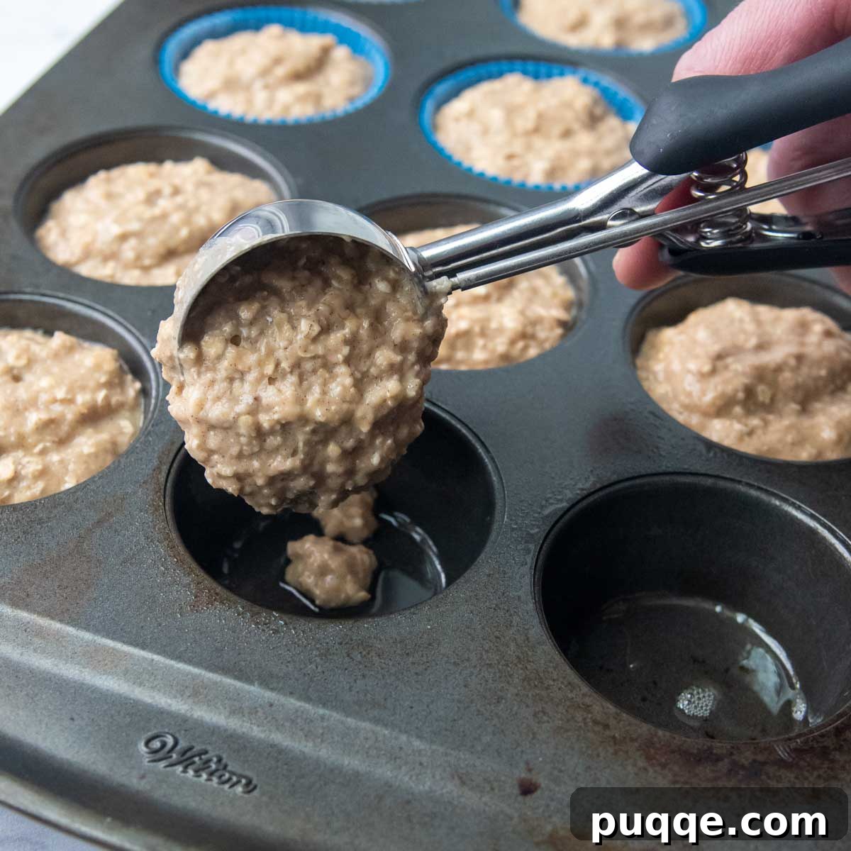 Wholesome Applesauce Oat Muffins 6 A trigger scoop efficiently portioning muffin batter into a baking tin.