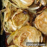 Golden Crispy Cabbage Steaks 7 Overhead shot of perfectly golden oven roasted cabbage steaks on a baking sheet, with visible crispy edges and a tender center.