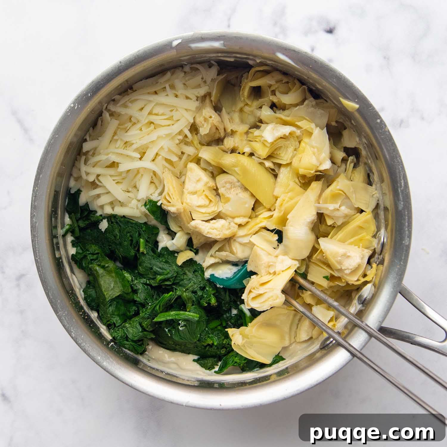 Velvety Fresh Spinach Artichoke Dip 7 The chopped artichokes and spinach being folded into the creamy cheese sauce, creating the final dip mixture.