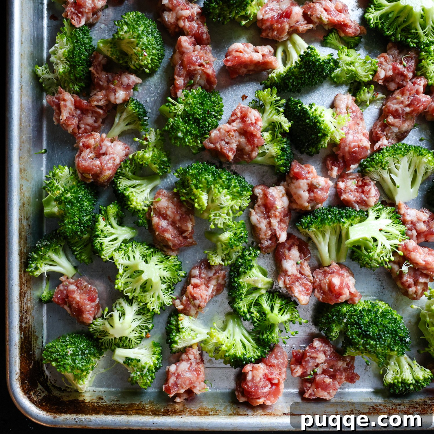 Roasted Gnocchi Sausage & Broccoli Sheet Pan Supper 5 Raw broccoli and Italian sausage on a sheet pan.