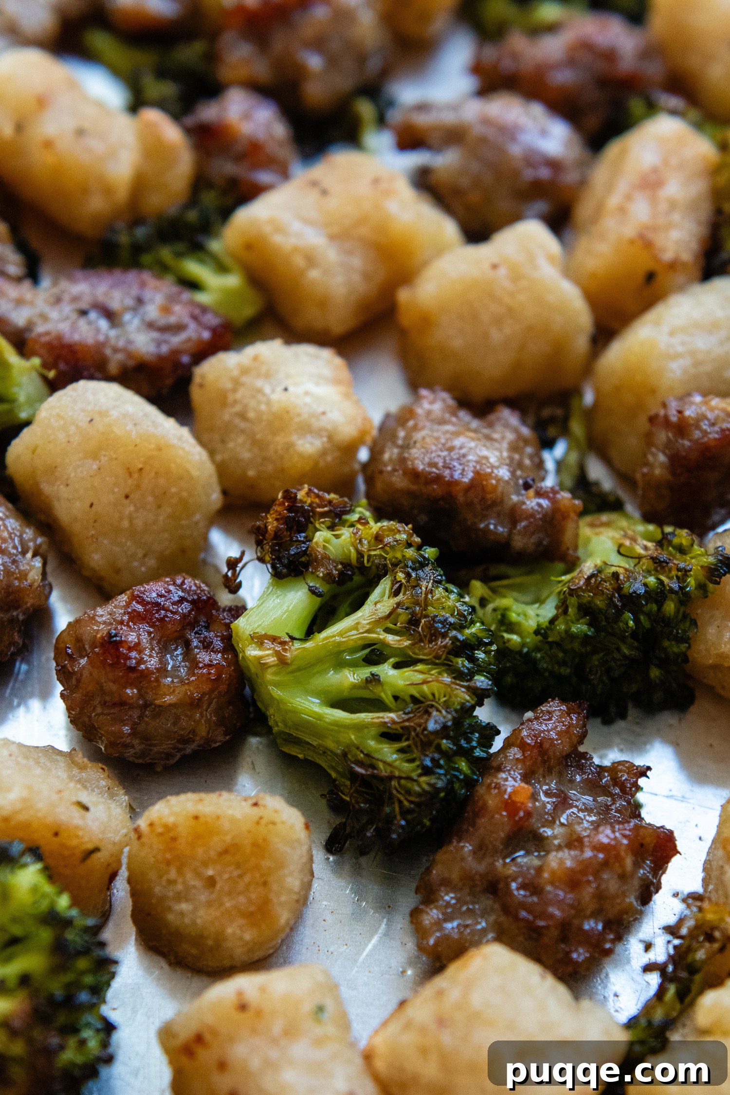Roasted Gnocchi Sausage & Broccoli Sheet Pan Supper 7 Close up of cooked gnocchi, broccoli and sausage on a sheet pan,