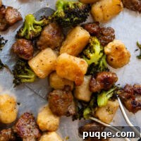 Roasted Gnocchi Sausage & Broccoli Sheet Pan Supper 8 Close up of cooked gnocchi, broccoli and sausage on a metal spatula.