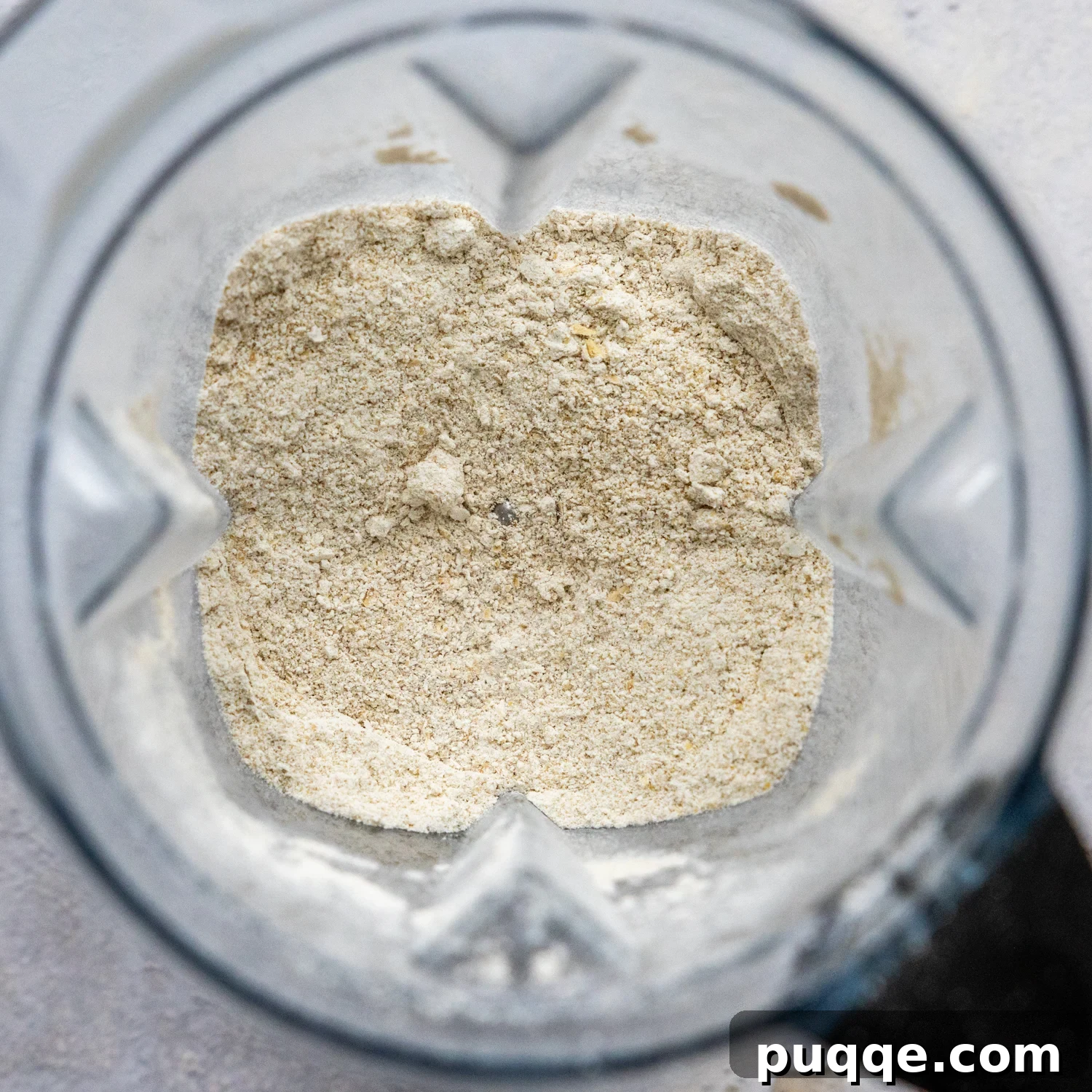 Pillowy Soft Gluten Free Oat Flour Banana Muffins 3 Rolled oats being blended into fine oat flour in a high-speed blender.