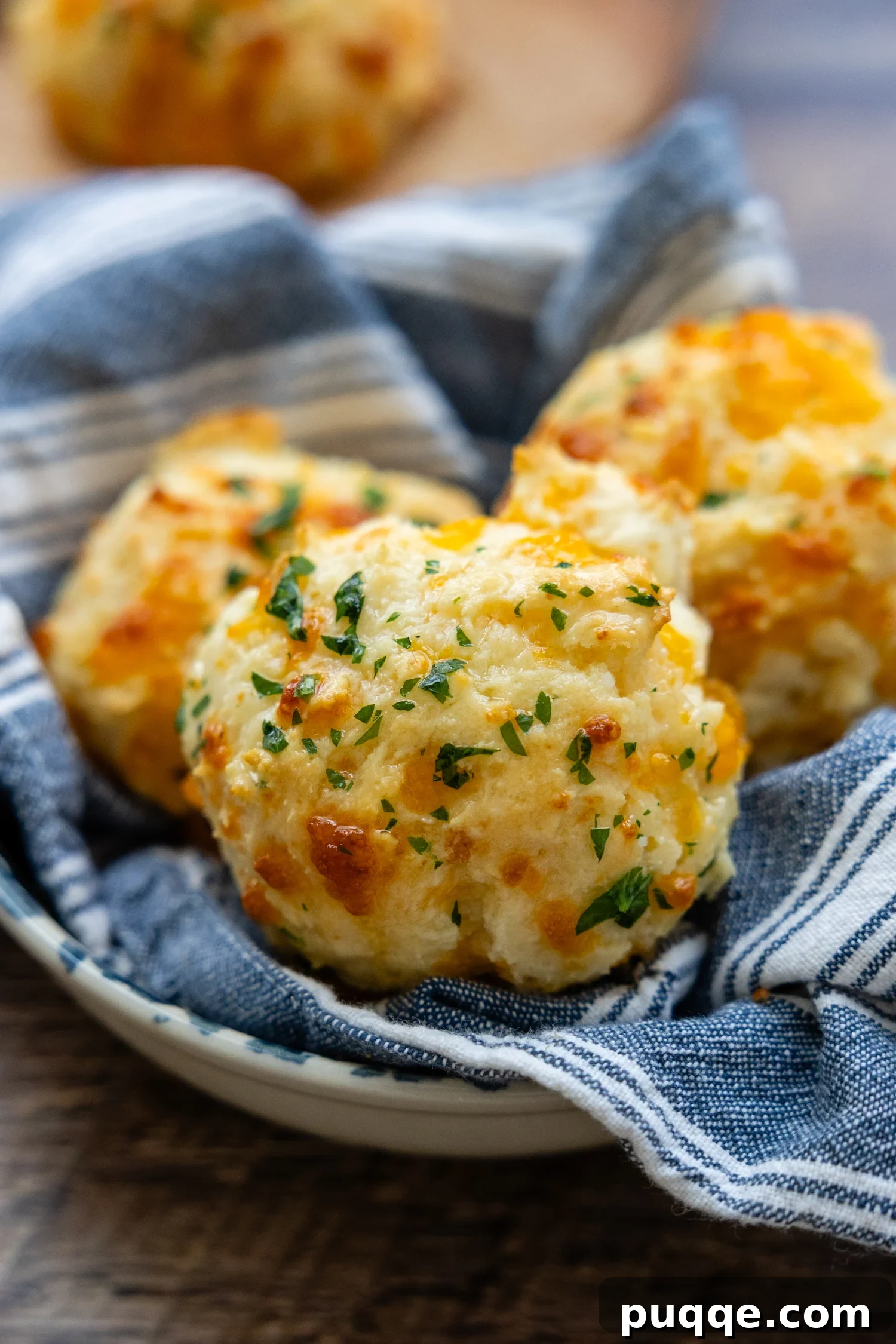 Restaurant Style Buttery Gluten-Free Cheddar Bay Biscuits 2 A basket full of golden-brown gluten-free cheddar biscuits, freshly baked and ready to eat.