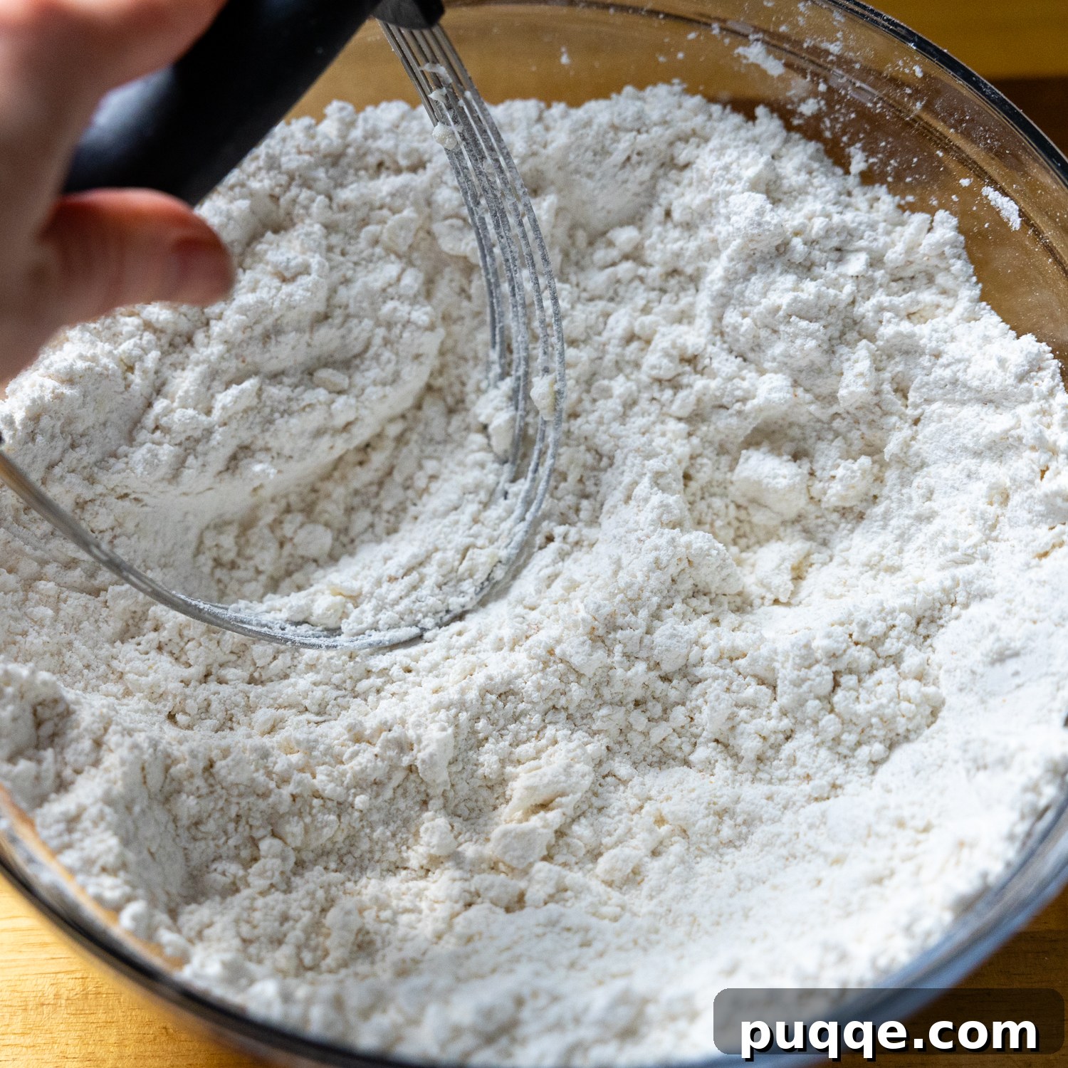 Restaurant Style Buttery Gluten-Free Cheddar Bay Biscuits 3 Cold butter being cut into a bowl of dry biscuit ingredients with a pastry blender.