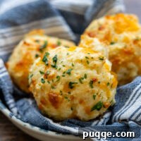 A basket of golden-brown gluten-free cheese biscuits, ready to be served.