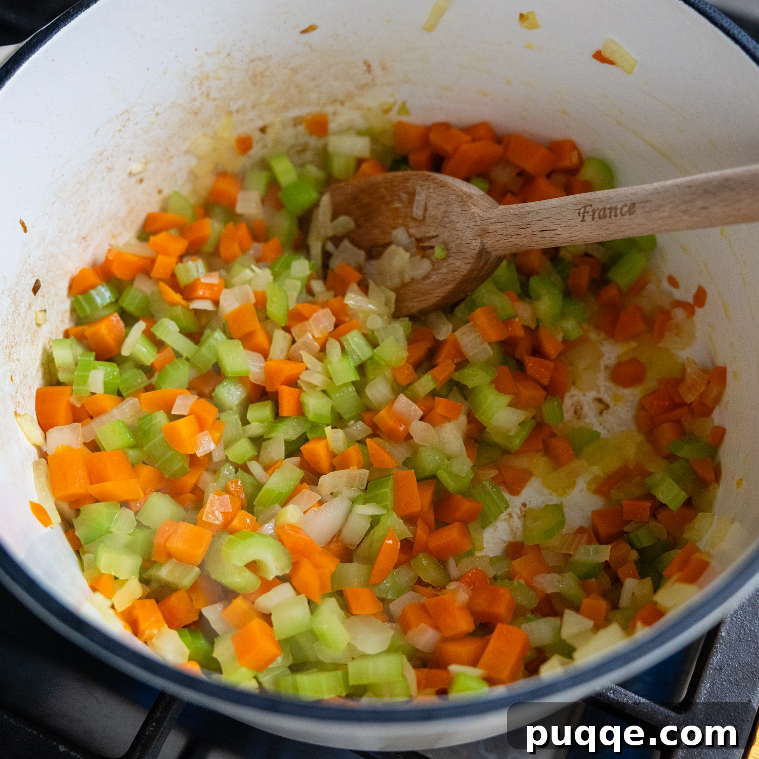 Diced carrots, celery, and onion sautéing in a stock pot with olive oil.