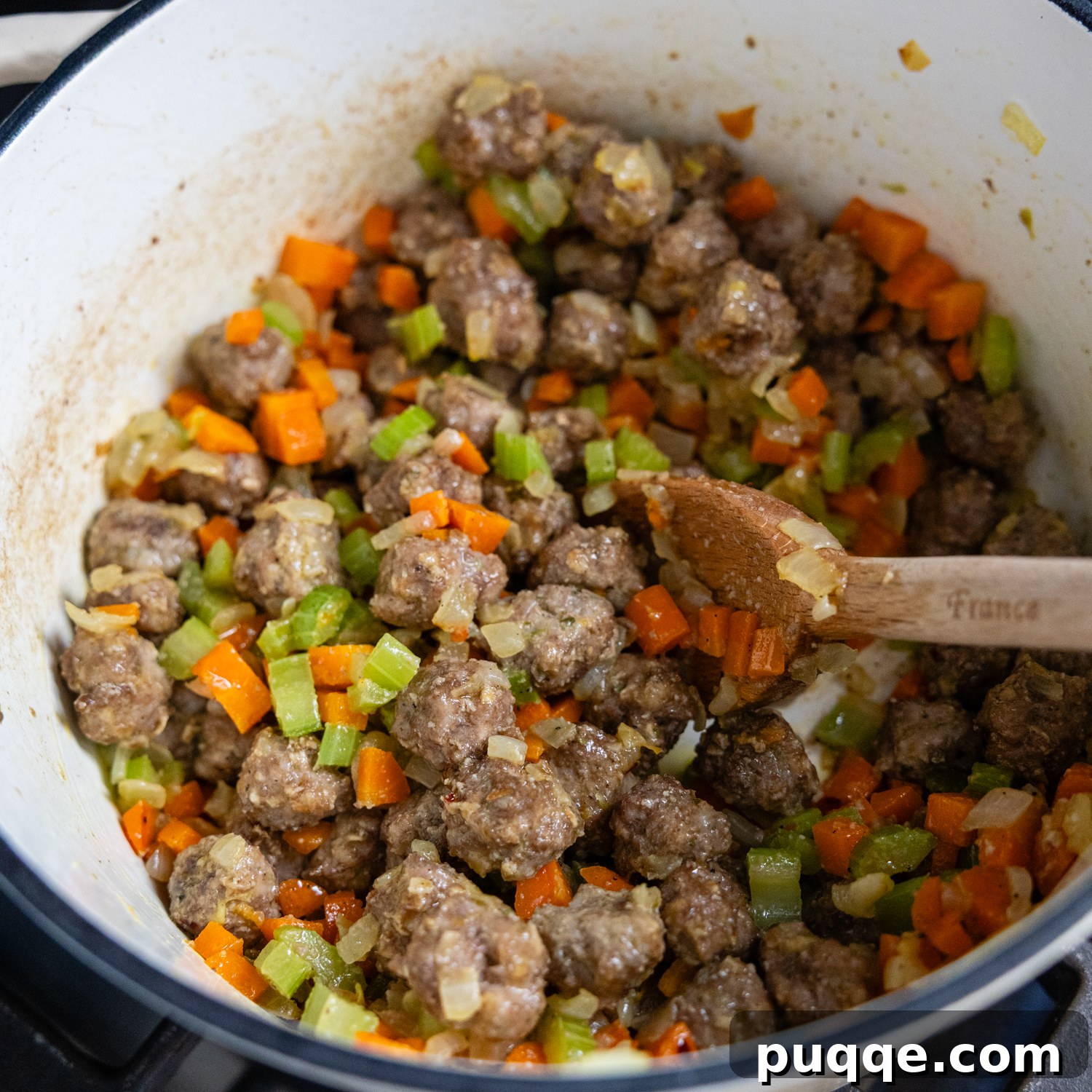 Oven-baked meatballs and sautéed vegetables combined in a large stockpot.