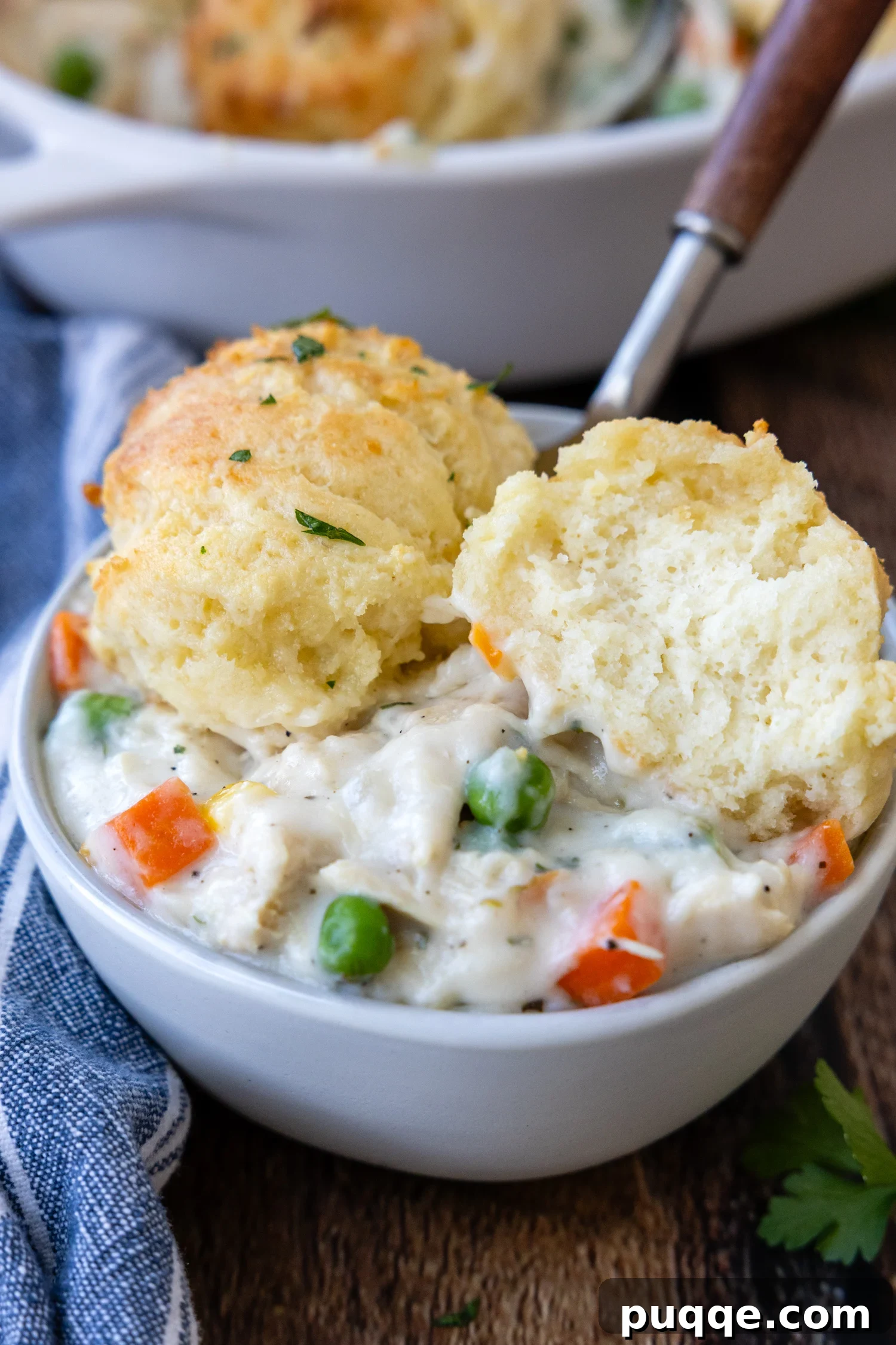 Cozy Gluten-Free Chicken and Biscuits 2 A bowl of Gluten-Free Chicken and Biscuits with a biscuit cut open to show its fluffy interior.
