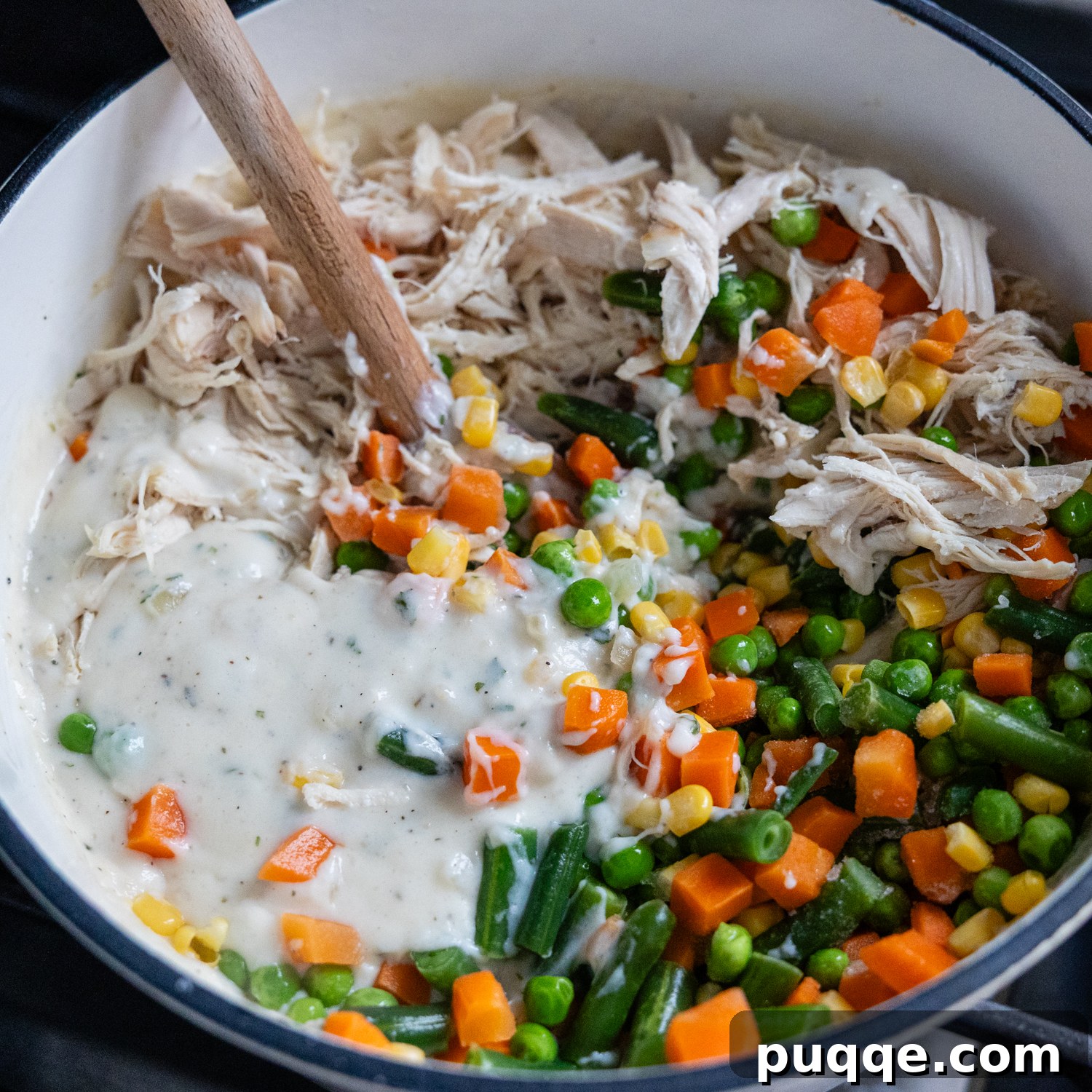 Cozy Gluten-Free Chicken and Biscuits 7 Cooked chicken and mixed vegetables being added to the creamy sauce.