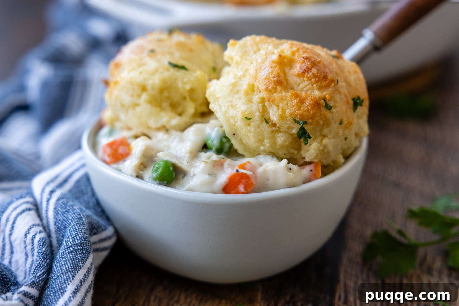 Cozy Gluten-Free Chicken and Biscuits 9 A white bowl filled with creamy gluten-free chicken and biscuits, ready to be enjoyed.