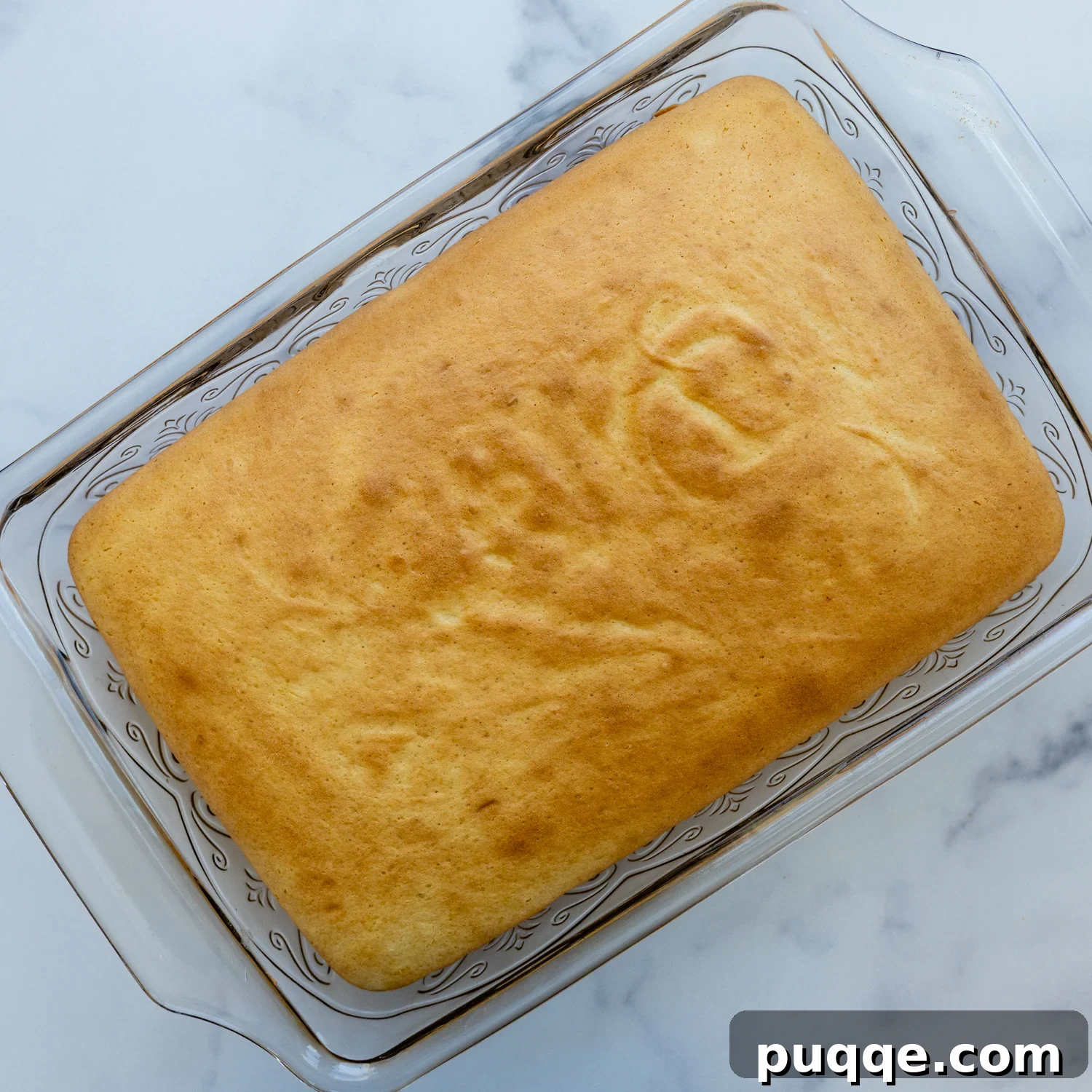 Absolutely Perfect Gluten-Free Tres Leches Cake 6 A freshly baked gluten-free cake resting in a glass baking pan.